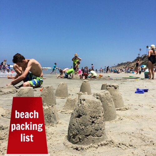 A group of people on a beach with sand castles in the foreground with text overlay.