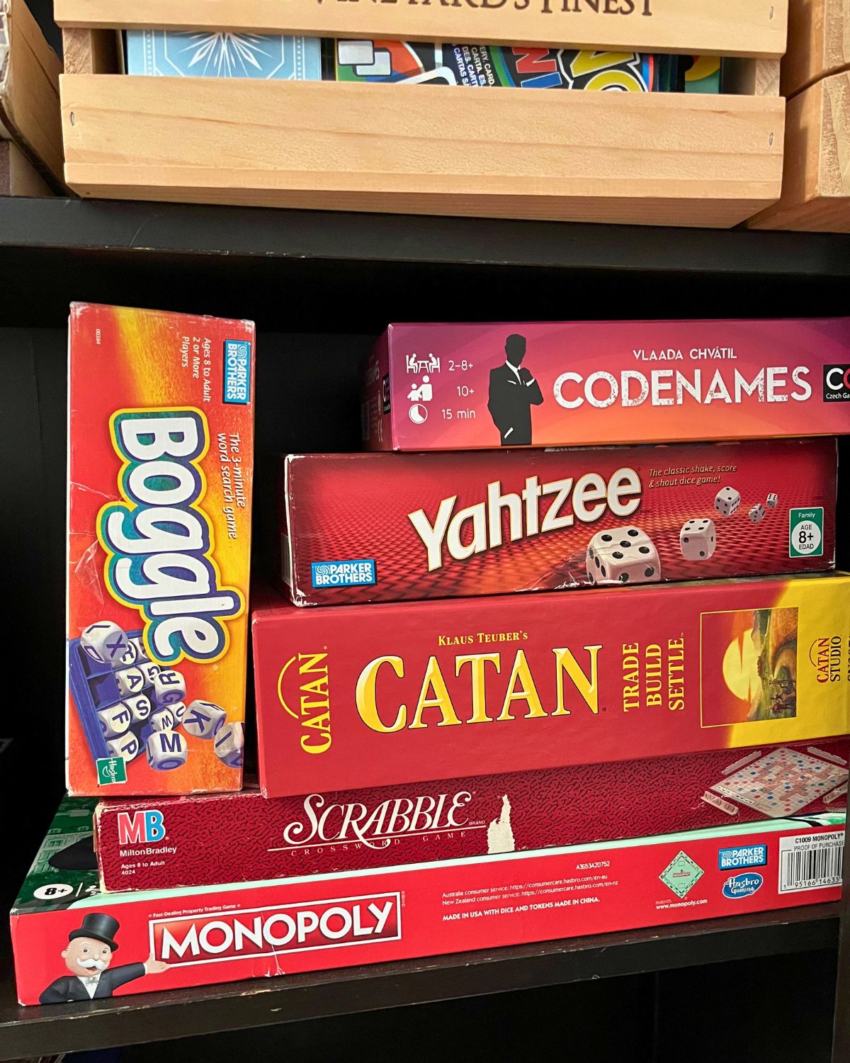 stack of red board games on shelf.