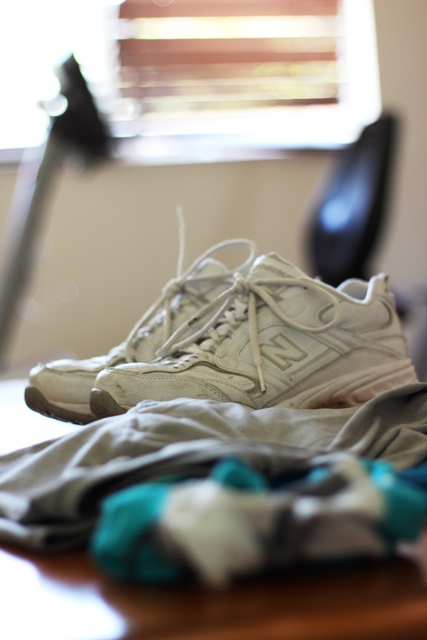 pair of tennis shoes with exercise bike in background.