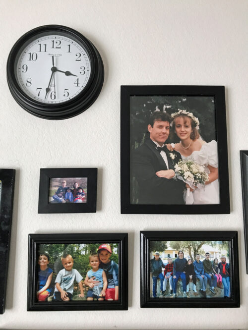 clock on wall surrounded by family photos
