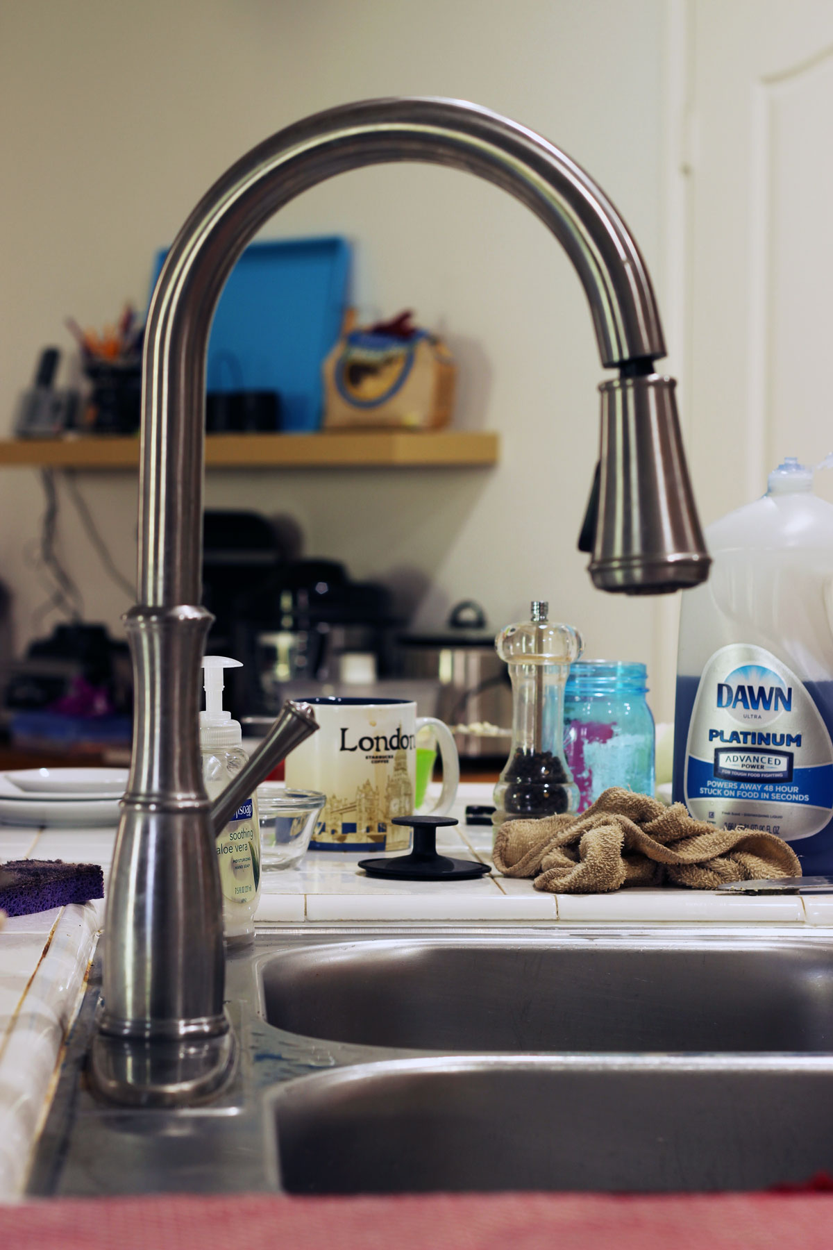 clutter on counter by kitchen sink