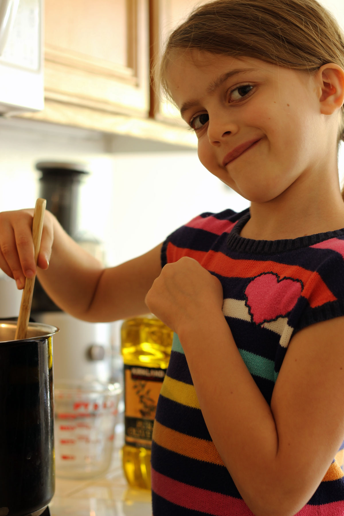 girl stirring pot of soup