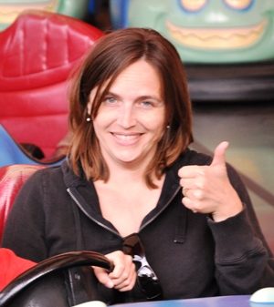 Jessica giving a thumbs up to the camera from a bumper car.