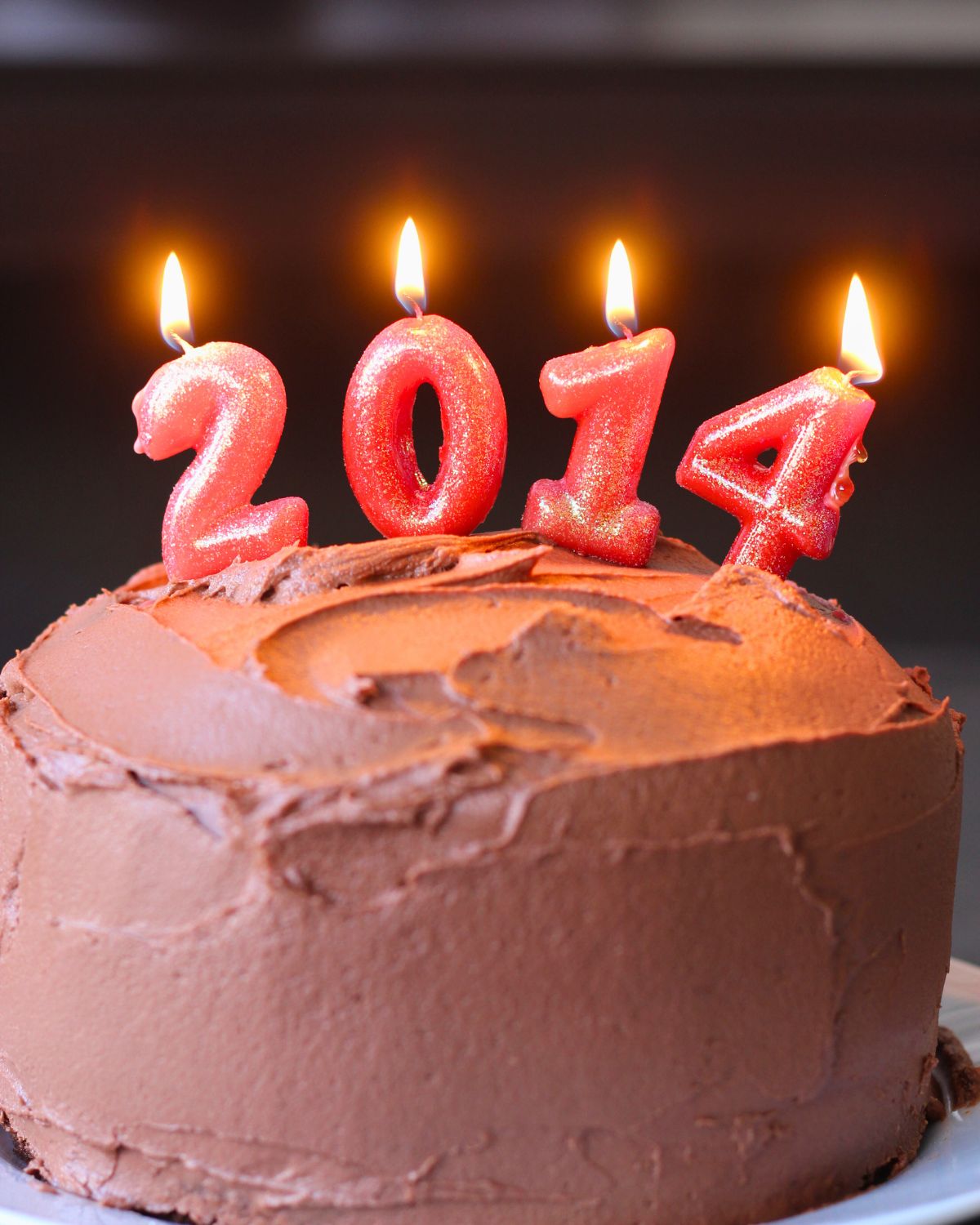 chocolate layer cake with 2014 number candles lit.