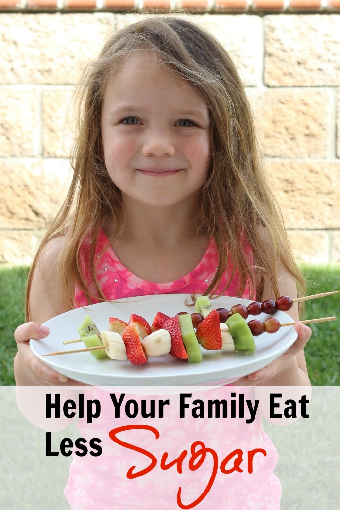 A girl holding a tray of fruit skewers