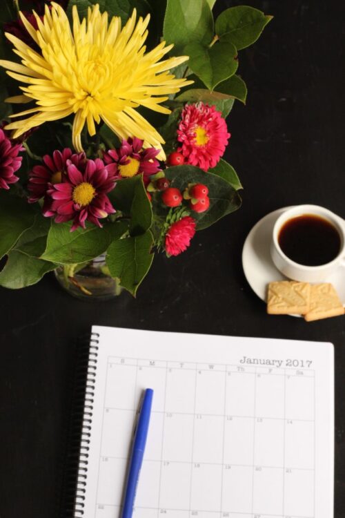 A cup of coffee on a flower, with Planner.