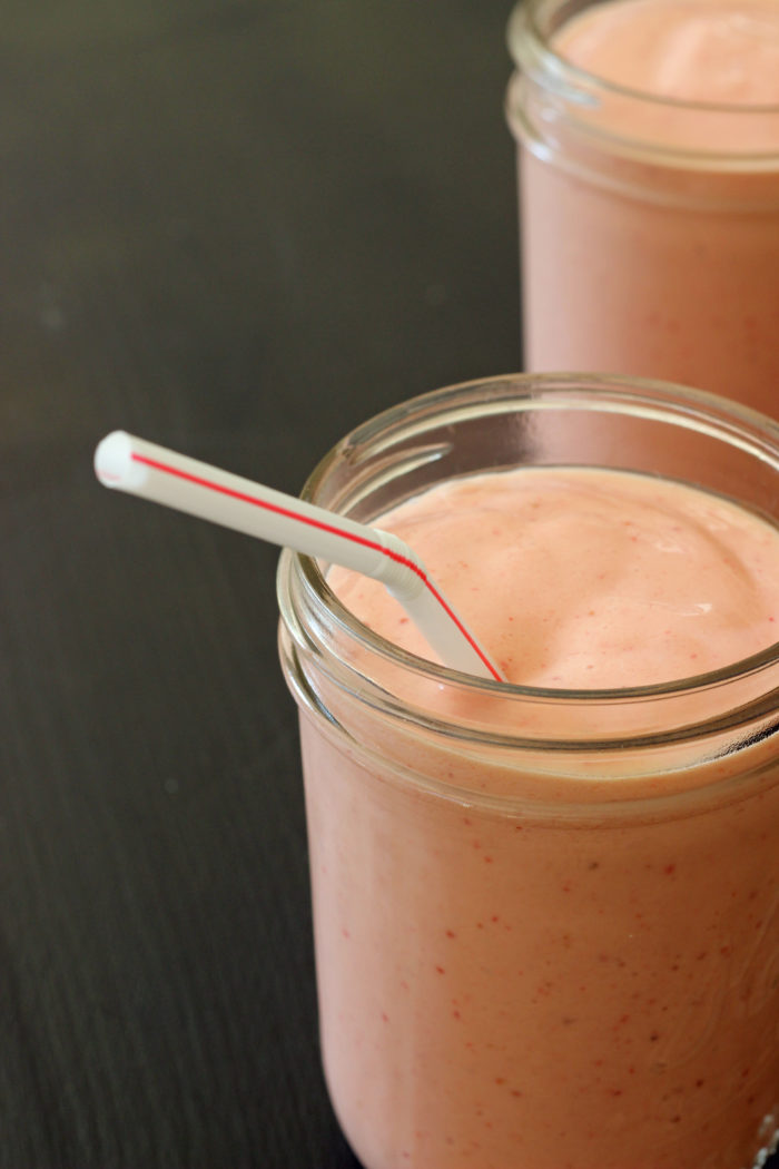 A smoothie in a mason jar with straw