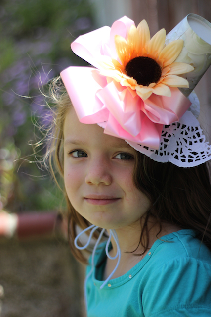 A little girl in a pink flower hat.