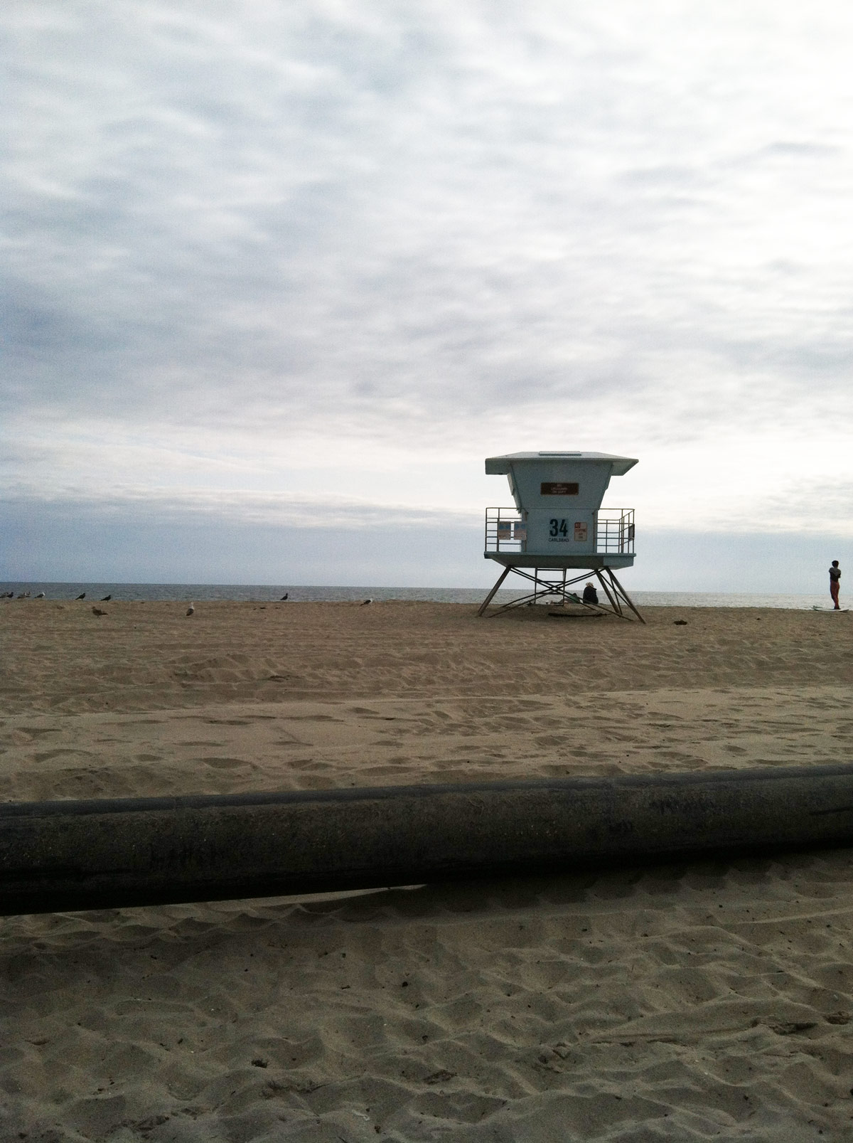 unmanned lifeguard tower on empty beach.