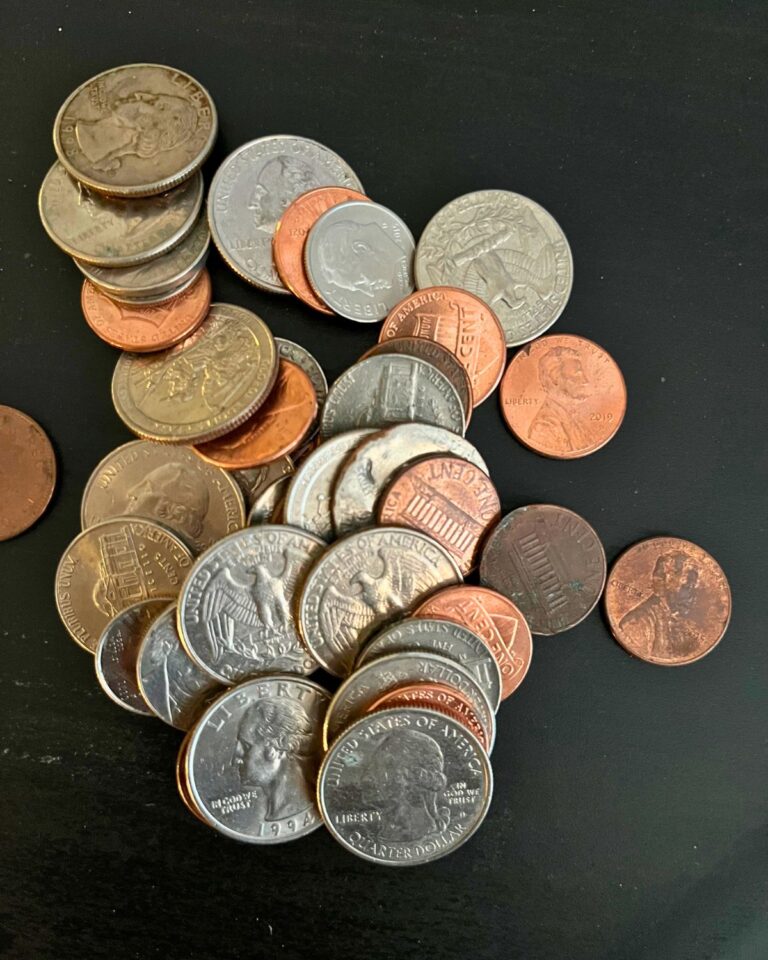 pile of US coins on a black table.