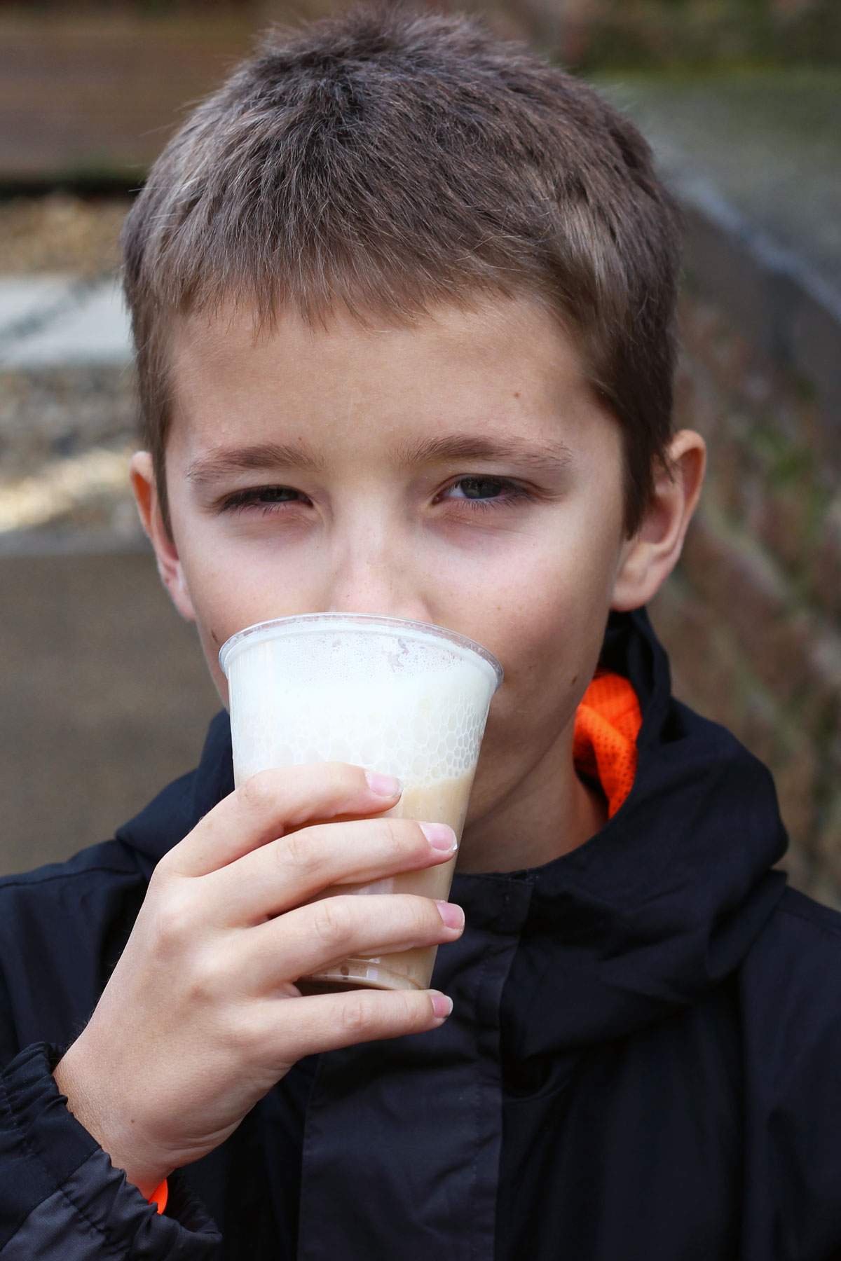 boy drinking a butter beer looking at the camera.