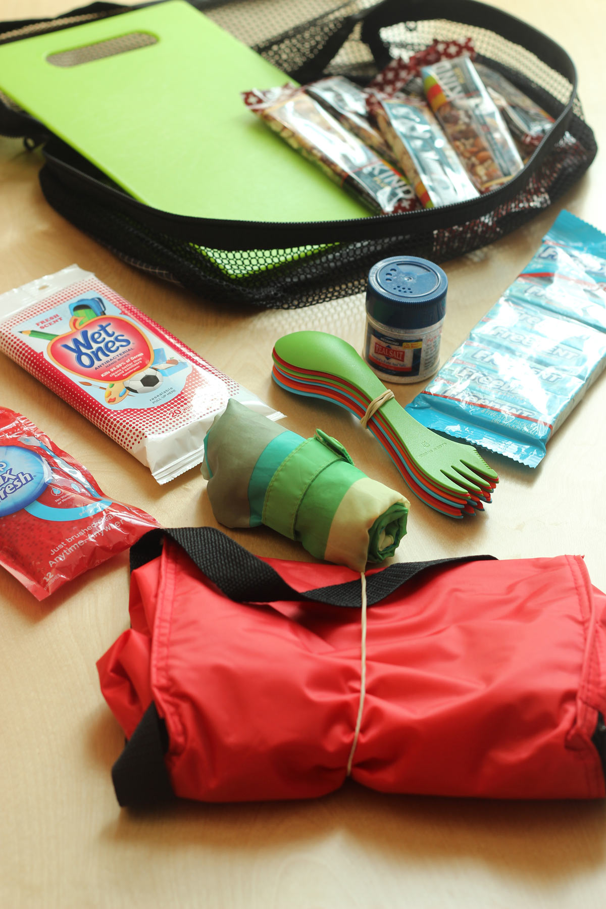 picnic pack of equipment including sporks, wipes, cooler bag, and cutting board.