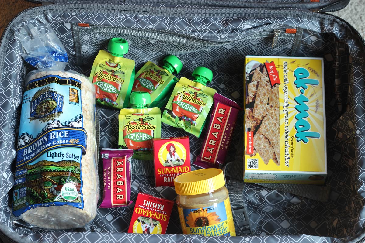 open suitcase with shelf stable foods in their packaging.