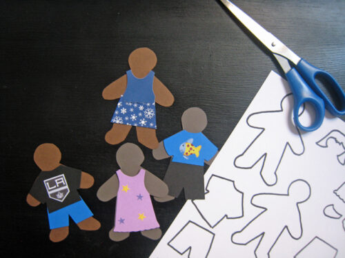 gingerbread people paper dolls next to template and scissors.