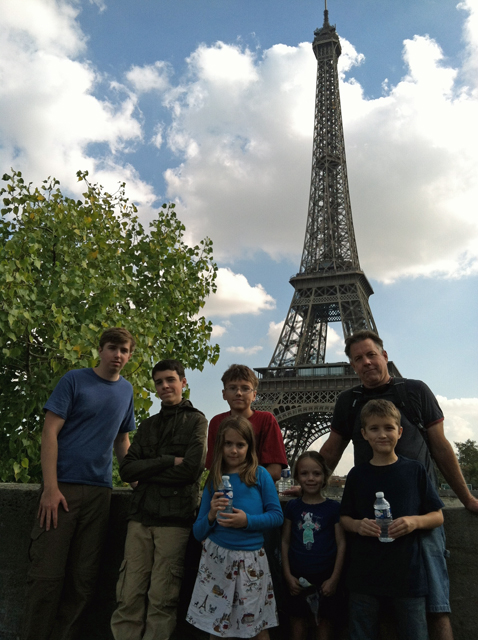 A family standing in front of the Eiffel tower.