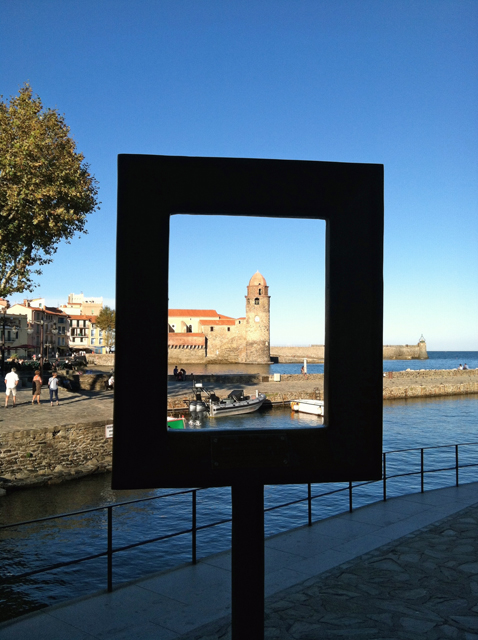 View of Collioure tower through a dark frame on the water.