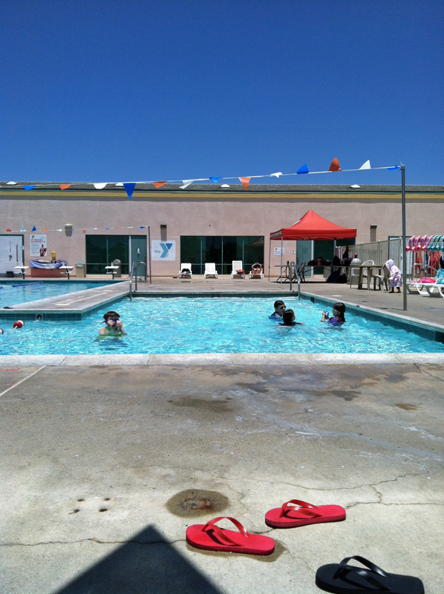 view of YMCA pool with families playing.