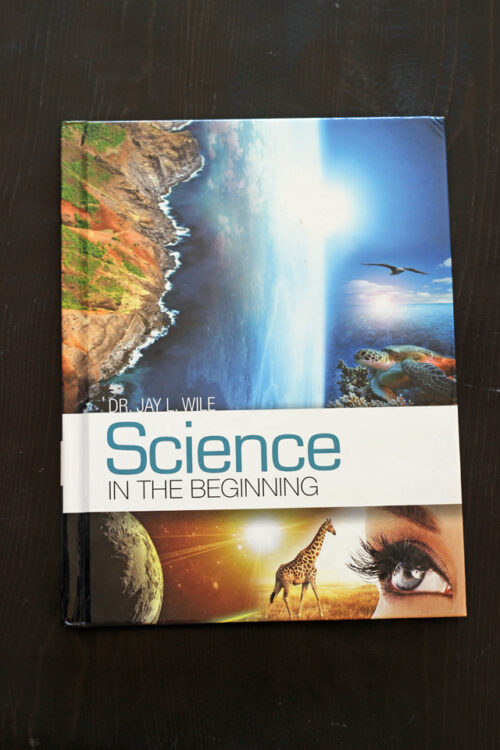 Overhead shot of Science textbook on black table.