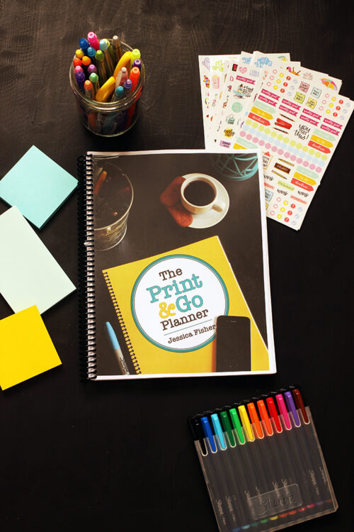 print and go planner on black table with pens post-its and stickers