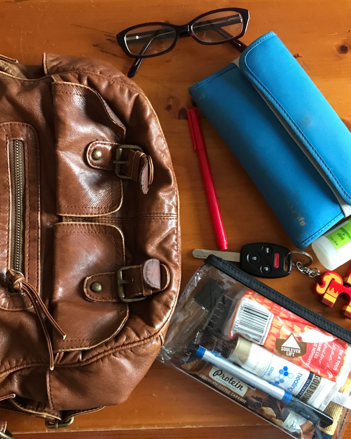 empty purse with stuff on table.