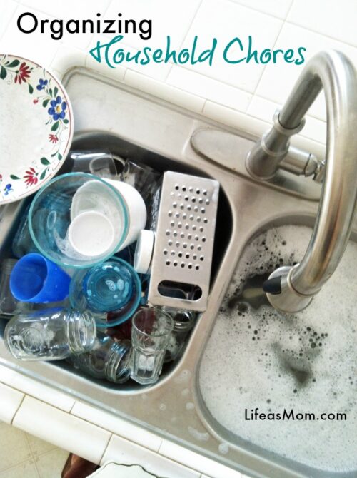 A close up of a sink filled with soapy dishes.