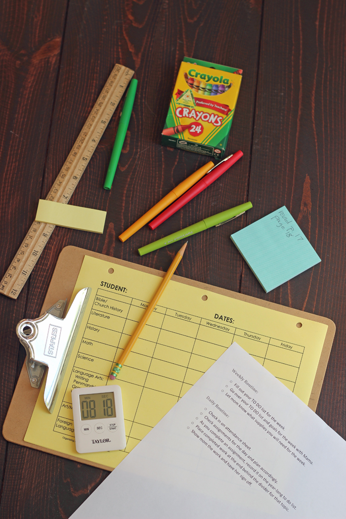 clipboard, lápis, temporizador e lápis de cera na mesa