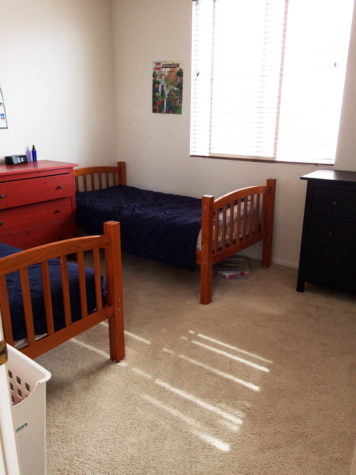 Two twin beds with blue comforters in a child\'s bedroom.