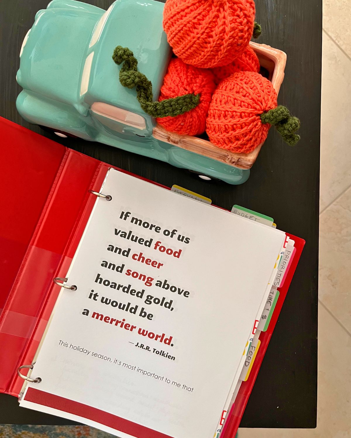 binder open to first page of holiday success kit, with fall decor nearby.