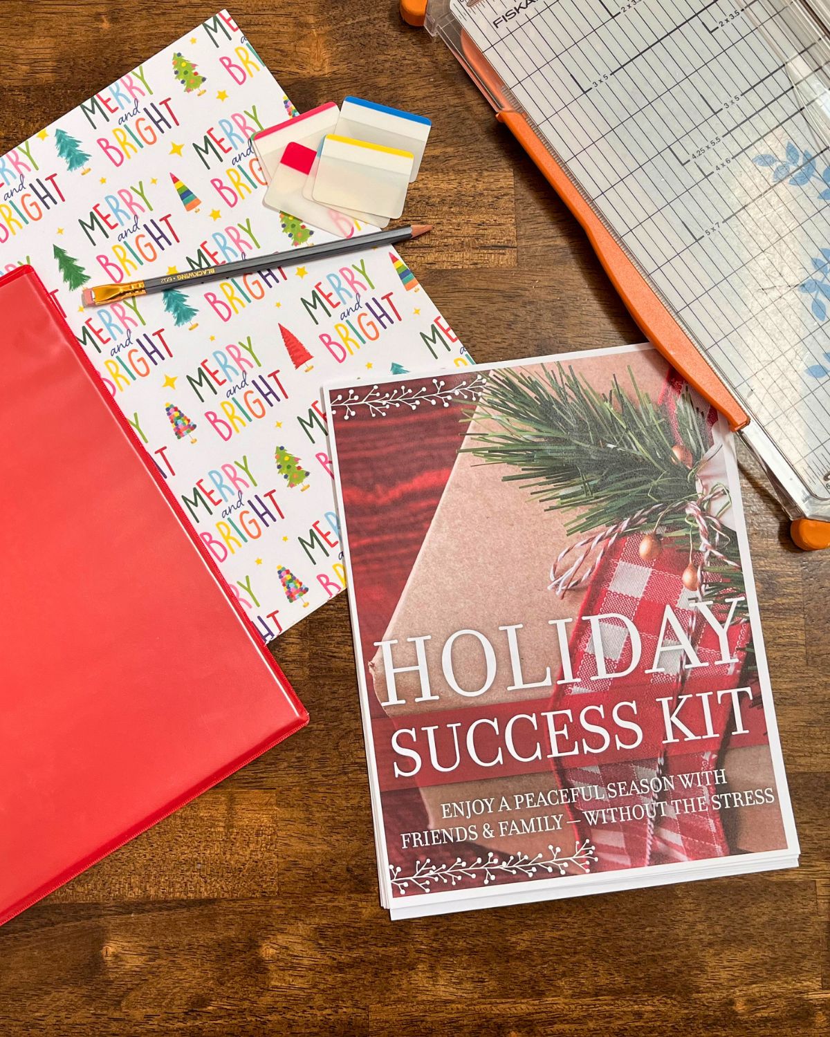 christmas notebook supplies laid out on a wood table.