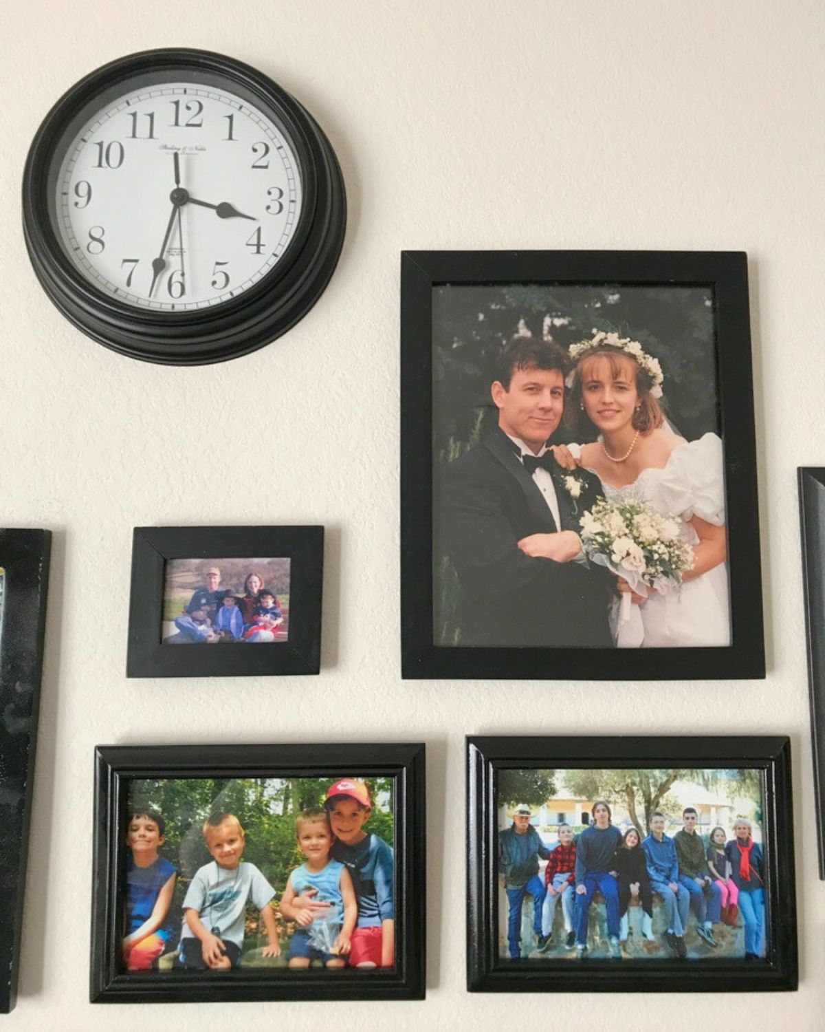 large clock on a picture wall with family photos.