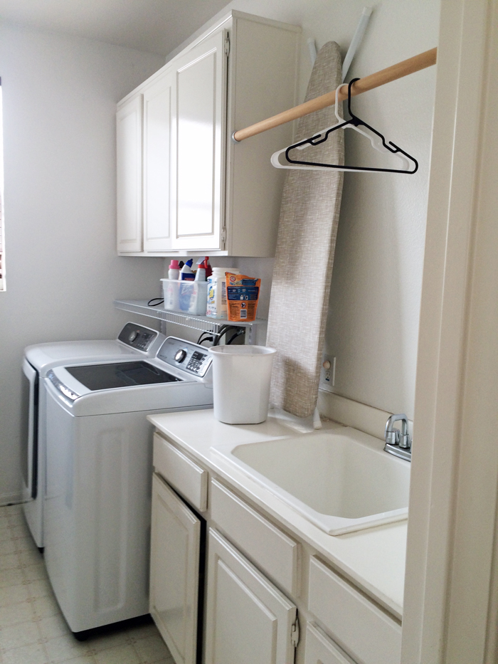 A laundry room with a sink and clothes rod overhead.