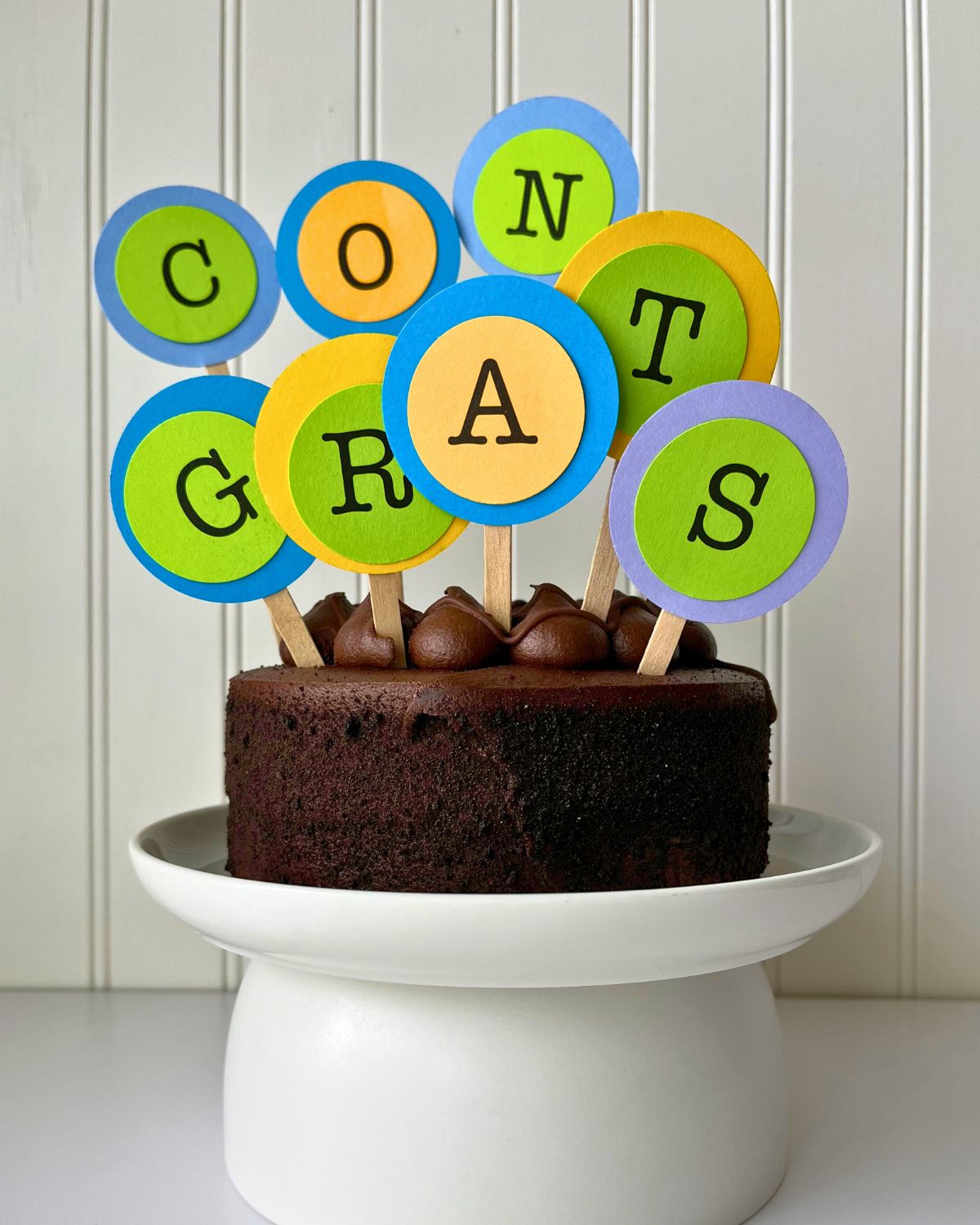 chocolate cake with congrats spelled out in cake toppers.