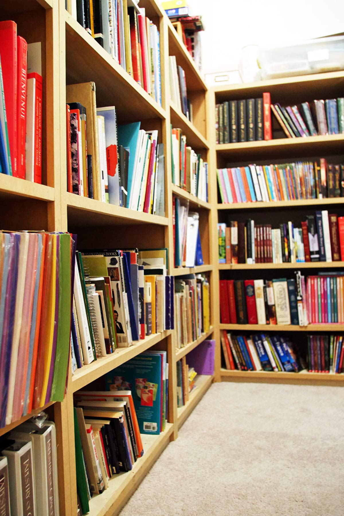 plain pine bookcases filled with homeschool books.