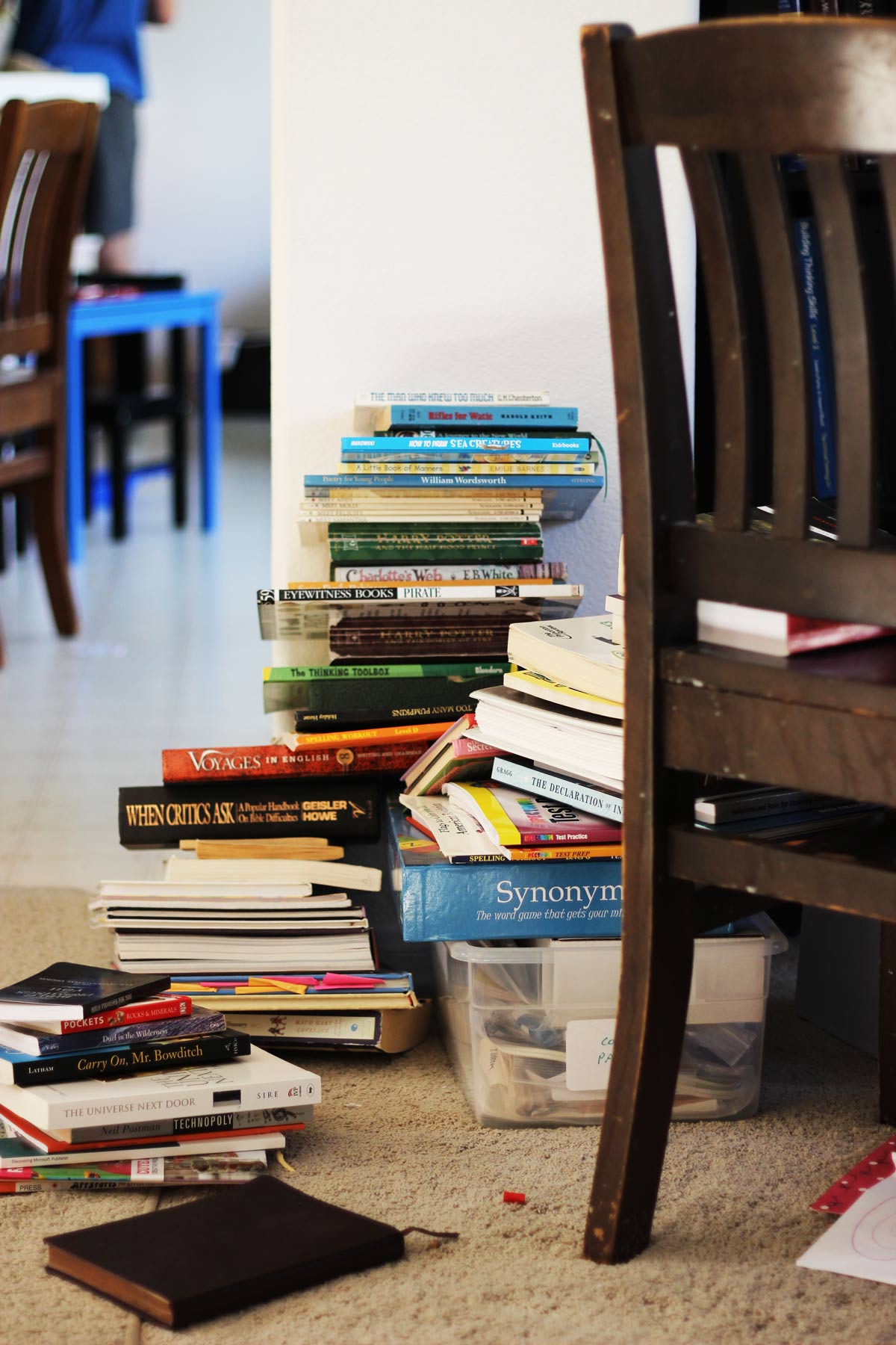 messy stacks of books on floor in school room.