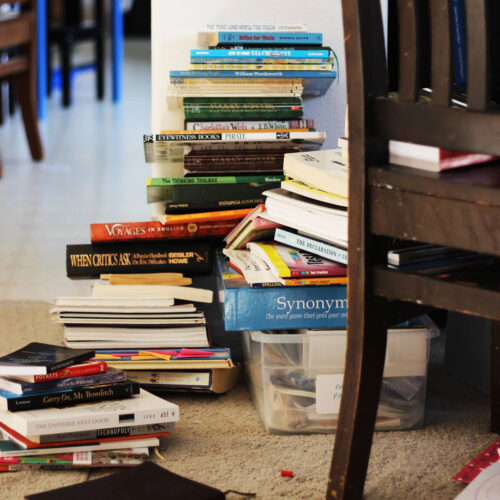 messy stack of books on floor.