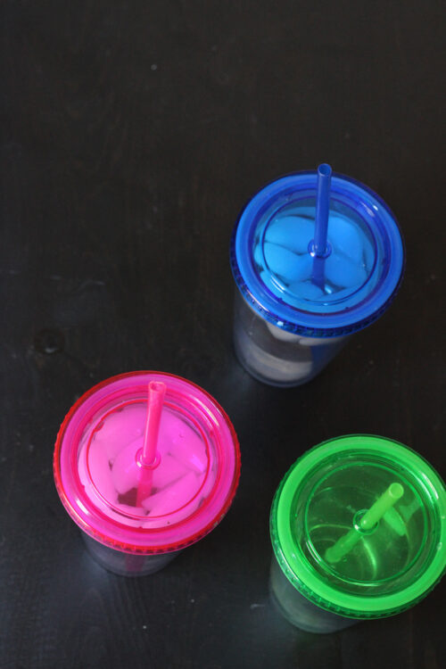 Colored travel tumblers filled with ice water.