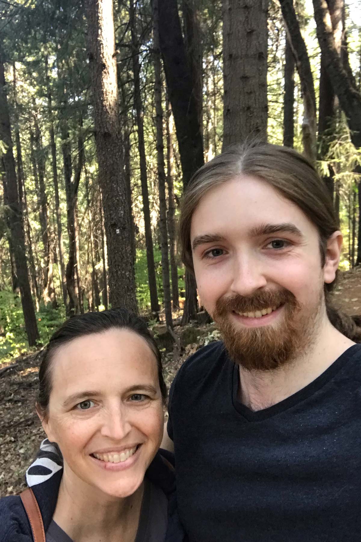 mom and grown son in the forest.