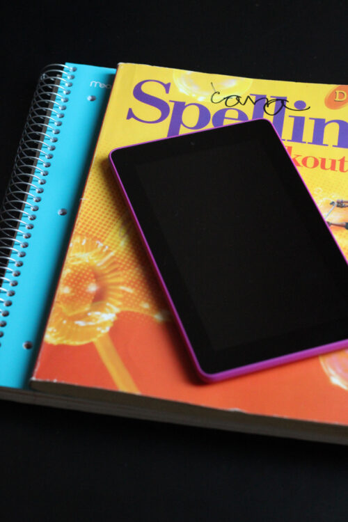 pink kindle on stack of school books
