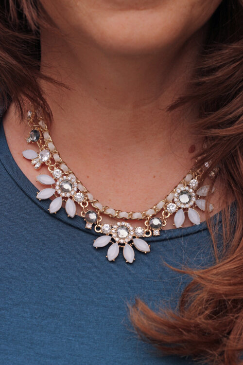 A woman wearing a gemstone necklace.