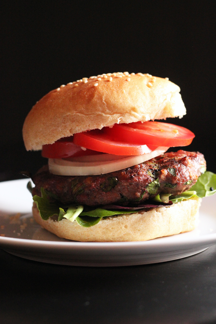 A close up of a Hamburger with tomatoes