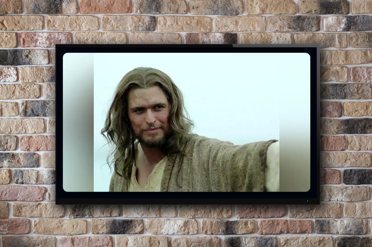 brick wall with a big screen tv and an actor playing jesus on the screen.