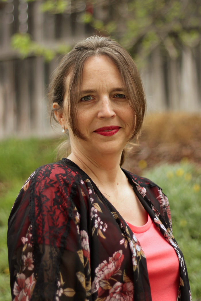 A woman wearing a coral blouse and black kimono.