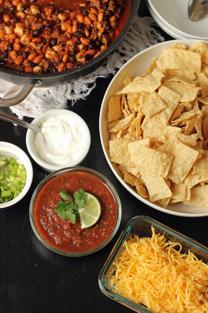 A bowl filled with salsa and other toppings, with chips