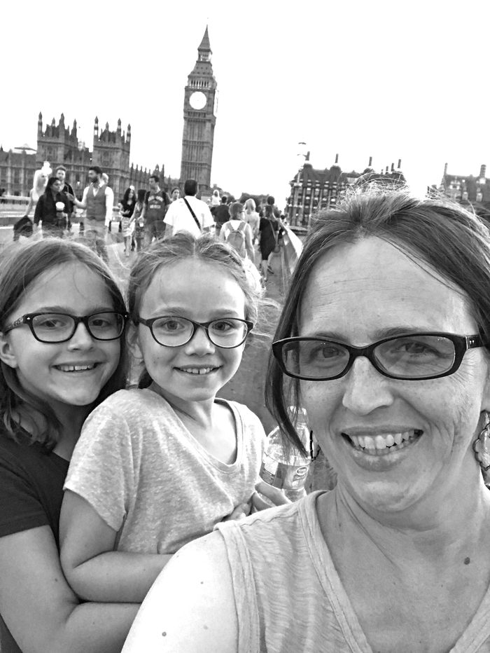 Mom and girls smiling at camera in front of Big Ben.