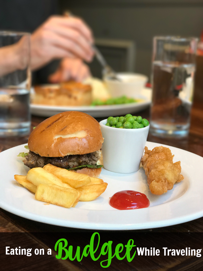 A person sitting at a table with a plate of food, at a pub