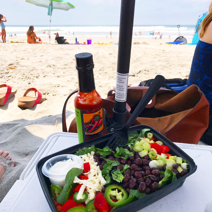 sitting at the beach with a packed taco salad