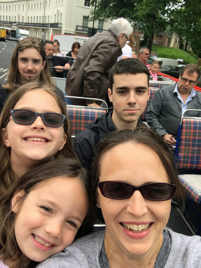 Mom and kids posing for the camera on top of bus in York.