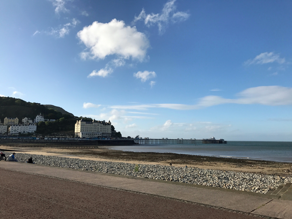 A sandy beach next to the ocean in Wales.