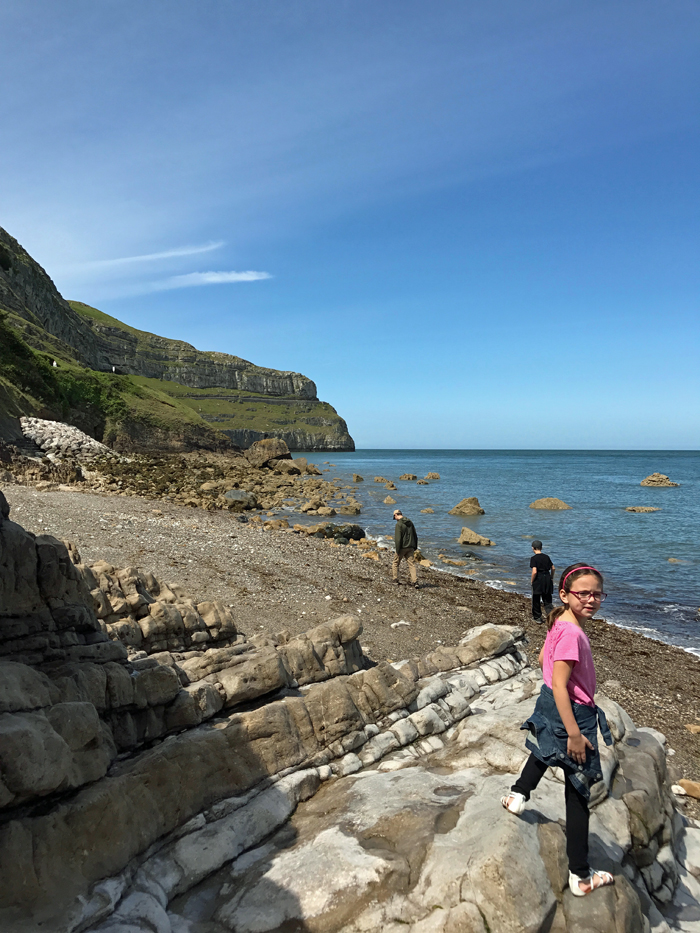 A group of people on a rocky beach in Wales.