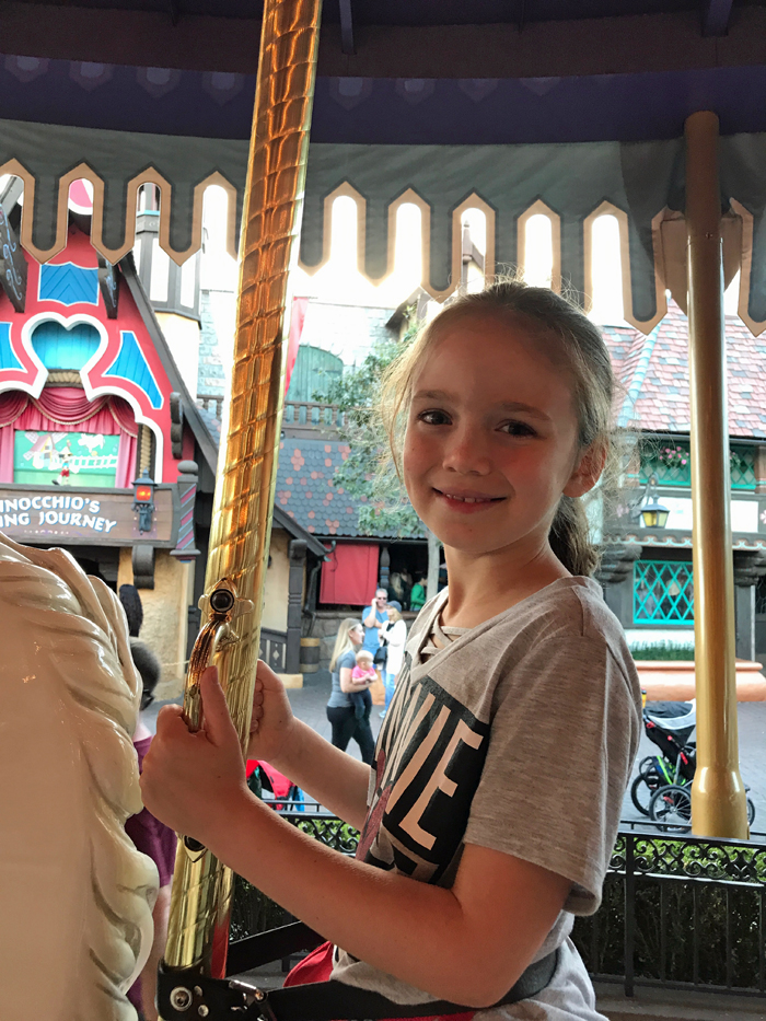 A girl on a the carousel at Disneyland.
